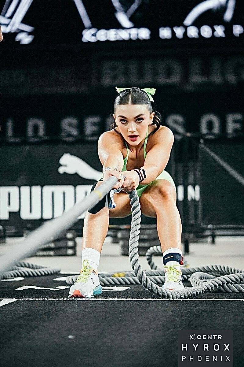 Lauren competing in a HYROX race with battle ropes.